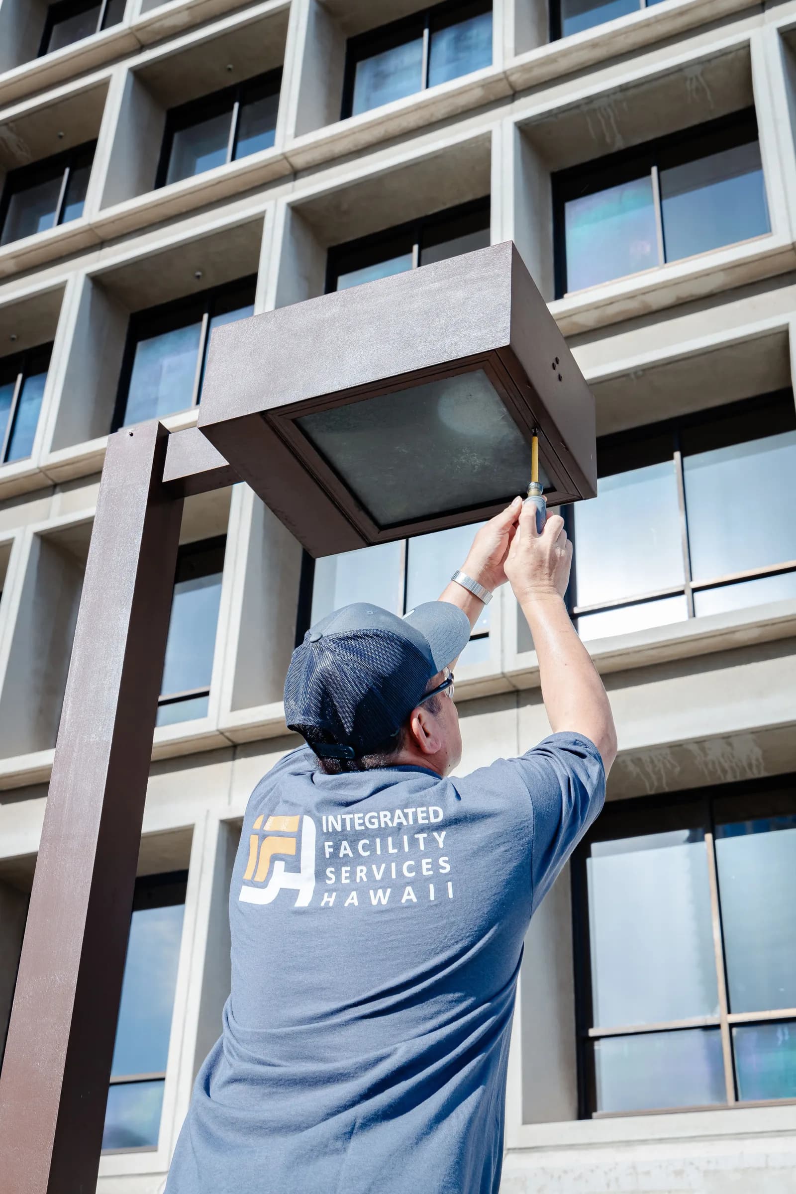 IFSH team member performing exterior fixture maintenance