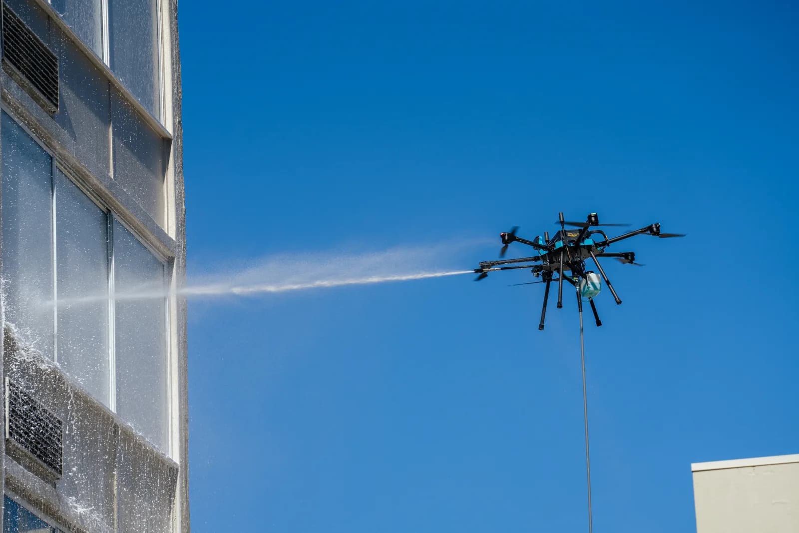 Cleaning drone spraying a high-rise building facade